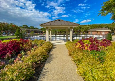 Manicured Walkway Leading Toward Fenced-In Swimming Pool Area