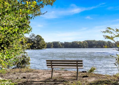 View Featuring Wooden Bench Overlooking Calm Body Of Water